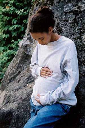 pregnant woman holding her belly and thinking about adoption
