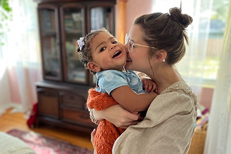 Adoptive mom Gabrielle hugging her adopted daughter